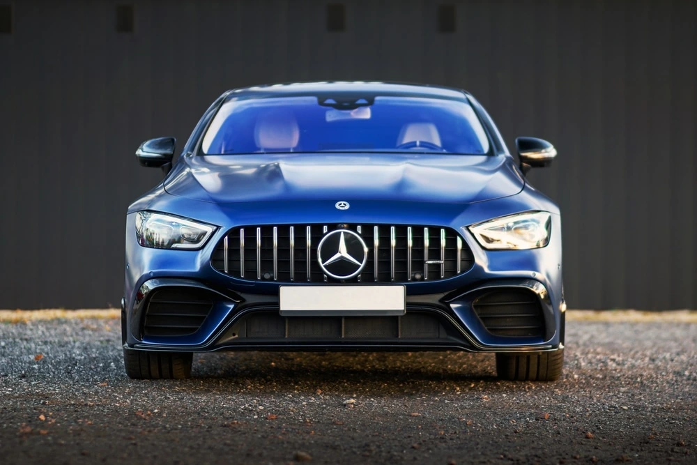 Front view of a blue Mercedes-Benz parked outside a building